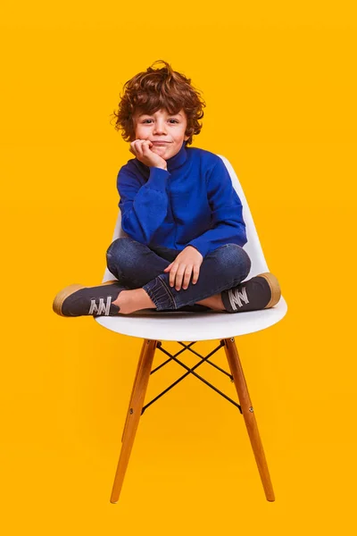 Стильний хлопчик сидить на стільці — стокове фото