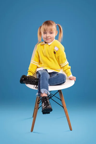 Aranyos lány ül a széken — Stock Fotó