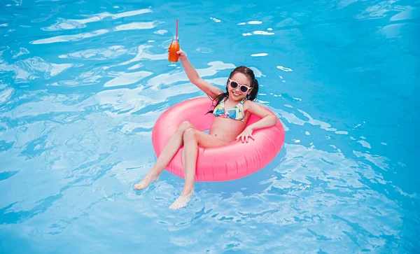 Criança encantada com refrigerante de bebida de frutas na piscina — Fotografia de Stock