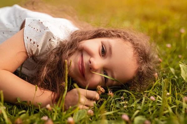 Menina feliz deitada no gramado — Fotografia de Stock