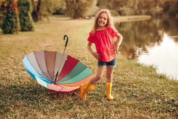 Щаслива дівчина з парасолькою на березі озера — стокове фото