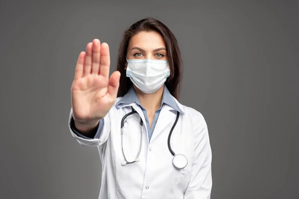 Sygeplejerske i maske gesturing stop - Stock-foto