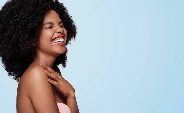 Optimistische zwarte vrouw lacht in de buurt van lege ruimte — Stockfoto