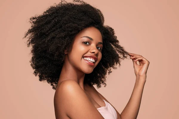 Счастливая черная женщина трогает чистые волосы — стоковое фото