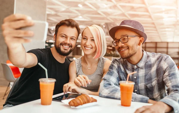 Diverse vrienden nemen selfie in cafe — Stockfoto