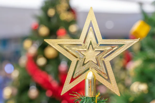 Beautiful Christmas star hanging from a decorated Christmas tree