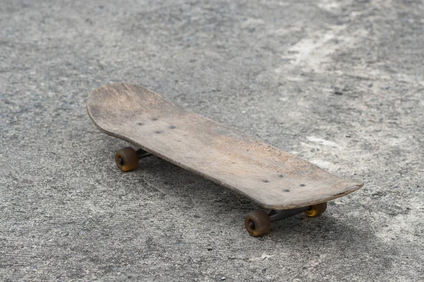 古いスケートボードを閉じますセメントの床の背景に影 — ストック写真