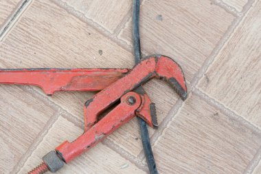 Beton zeminde paslı kırmızı boru anahtarı