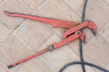 Beton zeminde paslı kırmızı boru anahtarı