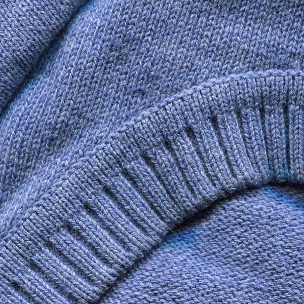 Blue knitted pullover background, close up. Knitted cloth texture of Princess Blue Color yarn. Fine-knit pure cashmere jumper. Soft blue angora background, closeup. Knitted sweater elastic, collar.