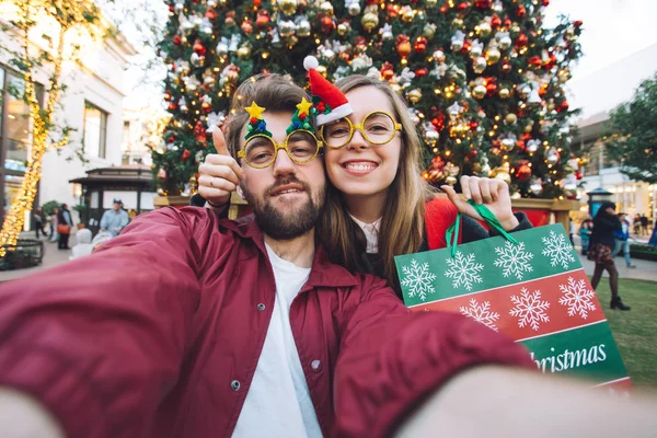 Happy couple making selfie near Christmas tree — Stock Photo, Image