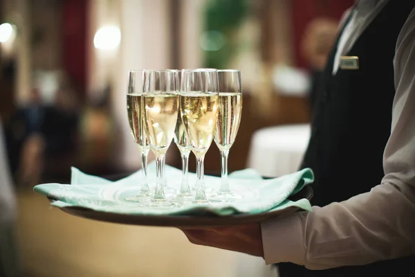 Camarero sirviendo champán en una bandeja Imágenes de stock libres de derechos
