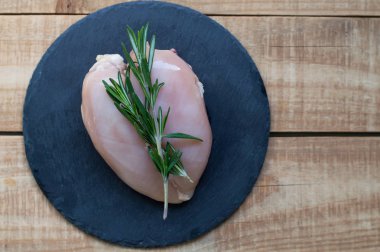 Çiğ tavuk göğsü taze biberiye bitki ile dekore edilmiştir. 