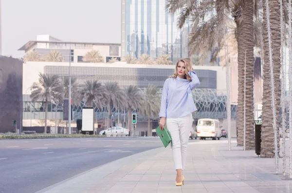 Snygg blond kvinna i smart casual blus och vita byxor — Stockfoto