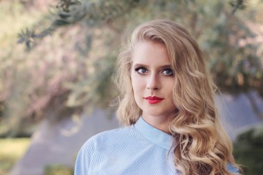 Sarışın kadın, mavi gözlü, kırmızı dudaklar ve kıvırcık blon portresi