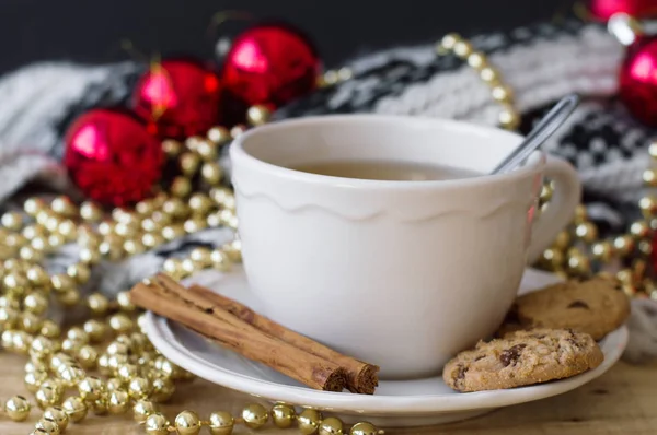 Tarçın ve çikolatalı kurabiye ve Noel dekorasyonu ile yeşil çay. Boncuk ve örme battaniye ile kırmızı Noel top, altın zincir. Noel Kahvaltı