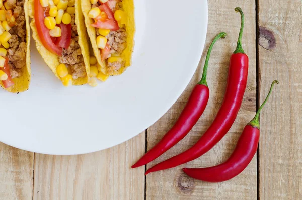 Üç baharatlı biber ve ahşap arka plan üzerinde Meksika tacos — Stok fotoğraf