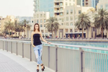 Bob ile genç kadın ayakta metal çit yakınındaki Dubai şehir kesti. Fashionista kumral ayakta rahat kıyafet boş Street ile