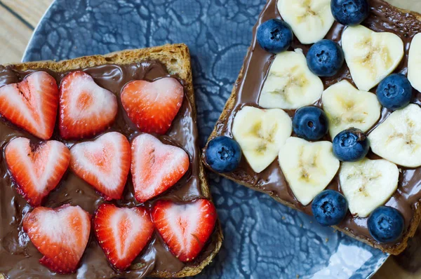 Fruit sandwiches with strawberry, banana, blueberry, chocolate butter and whole grain bread