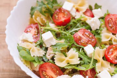 Ev yapımı makarna salatası kırmızı kiraz domates, beyaz peynir, tavuk göğsü ile büyük bir kısmı, Bebek ıspanak yaprakları, roka (roket yapraklar) ve farfalle