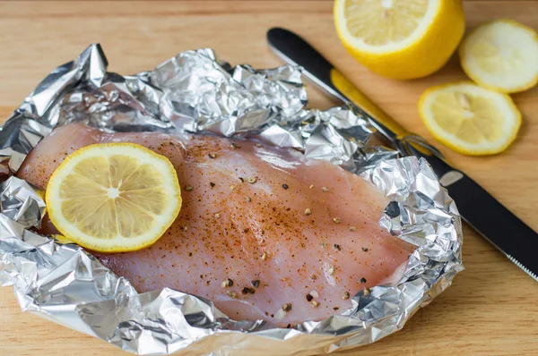 Rohe Hühnerbrust mit Zitronenscheibe, Pfeffer und Salz in Backfolie — Stockfoto