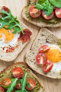 Yumurta, kiraz domates, roka, ıspanak, pesto sos, domates sosu ve baharat ile ekmek. Kahvaltı tost. Dengeli yemek