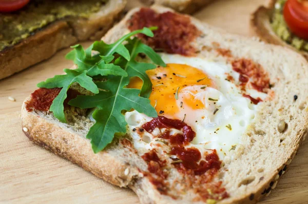 Yumurta, roka, domates sosu ve multicereal ekmek ile kahvaltı tost. Dengeli yemek. Sağlıklı sandviç