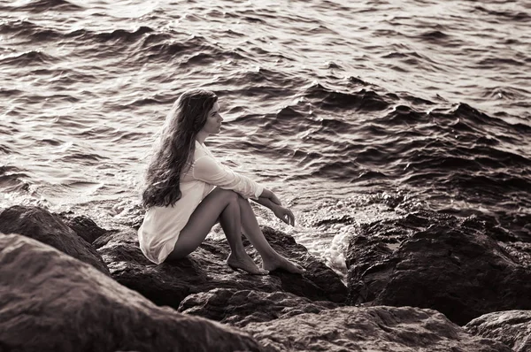 Beyaz Gömlekli Sahil Büyük Taş Oturan Genç Kadının Siyah Beyaz — Stok fotoğraf