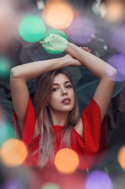 Dikey kırmızı elbise ve renkli bokeh etkisi güzel genç kadın portresi