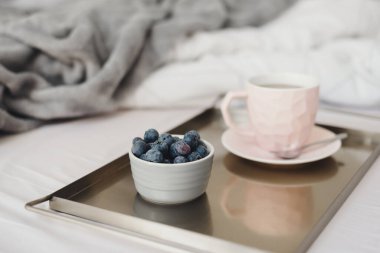 Metal tepside servis edilen bir fincan kahve ve taze yaban mersini. Yatakta kahvaltı. Sabah kahvesi