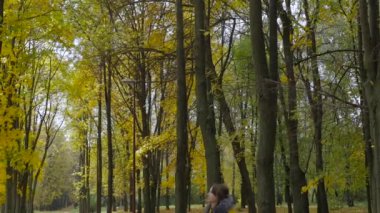 Sonbahar parkında yürüyen kız.