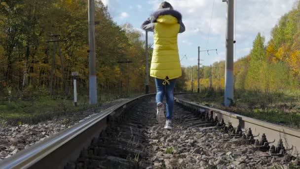 那个女孩在铁轨上走在秋天 — 图库视频影像