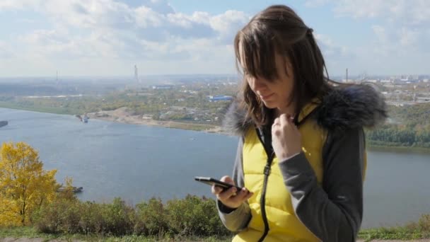 Flicka sitter på en bänk och tittar på panorama över staden — Stockvideo