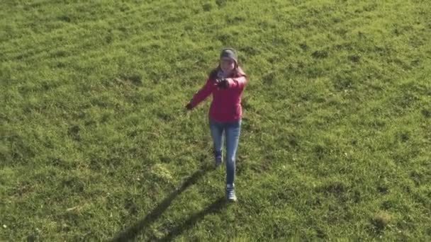 Girl running to camera on green field — Stock video