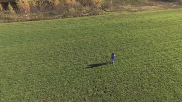 Молодой человек и девушка обнимаются на зеленом поле — стоковое видео