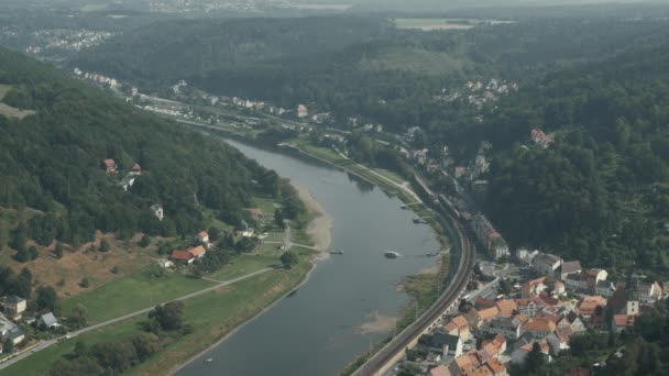 Поезд идет по реке через маленький городок. — стоковое видео
