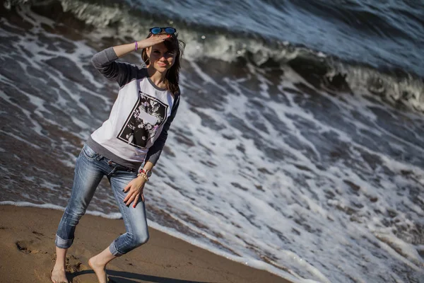 Kız sahilde yürüyor.