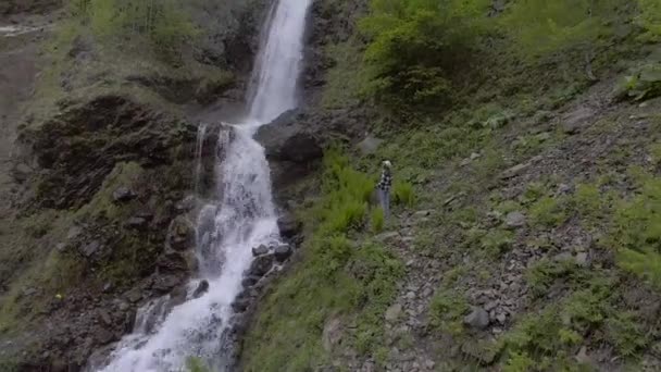 Девушка смотрит на водопад — стоковое видео