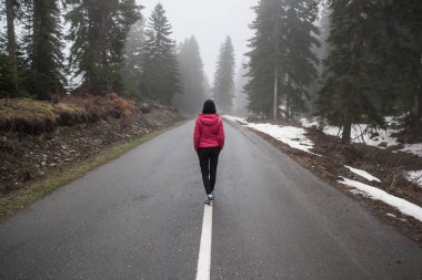 Genç bir kız puslu bir yolda standları