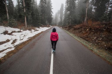 Genç bir kız puslu bir yolda standları