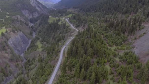 El coche monta en la serpentina carretera en las montañas — Vídeo de stock