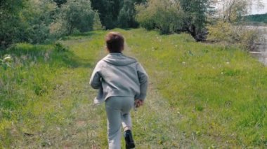 Küçük bir çocuk yol boyunca çalışır