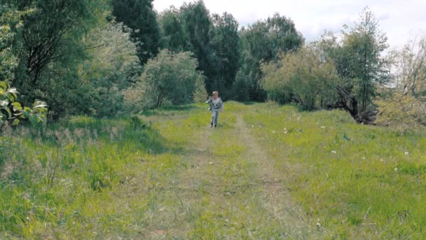 Ένα μικρό αγόρι που τρέχει κατά μήκος της διαδρομής — Αρχείο Βίντεο