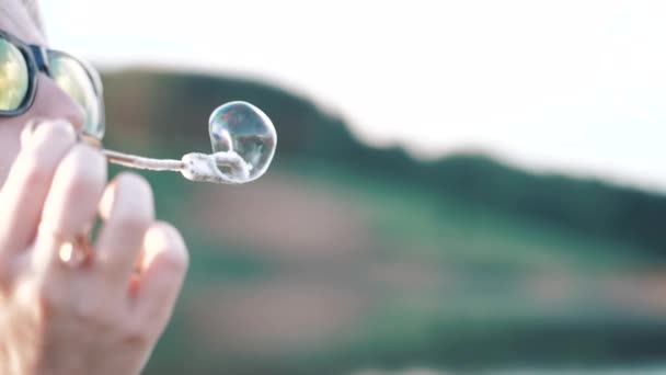 Girl inflates soap bubble — Stock Video