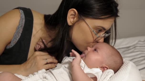 Mamá Acuesta Con Bebé Una Cama Blanca — Vídeos de Stock