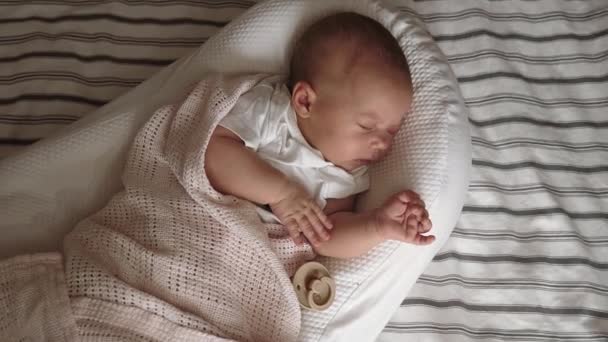 赤ん坊はベッドの上のクレードルで眠る — ストック動画