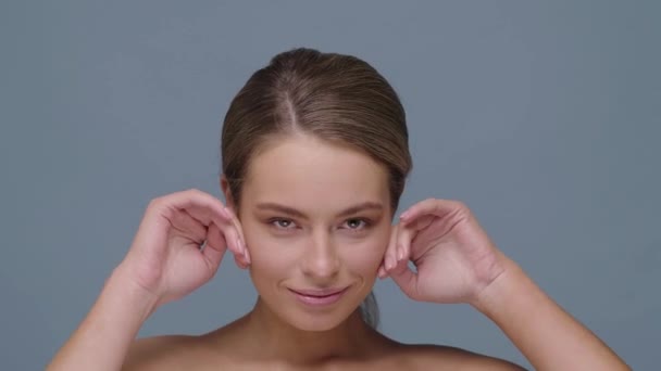 Mädchen Streicht Lächelnd Über Die Haut Gesäß Und Blickt Vor — Stockvideo