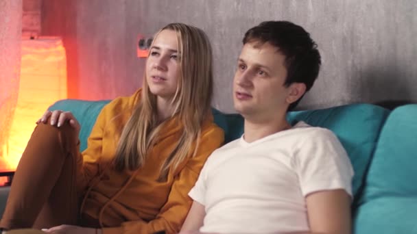 男と女の子はテレビを見てるソファに座って何かを議論してる — ストック動画