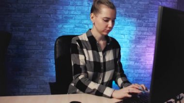 Kız bilgisayar masasında çalışıyor, kamera yavaş hareket ediyor.