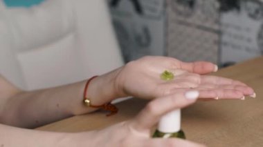 Kız antiseptikle yemeden önce ellerini dezenfekte ediyor.